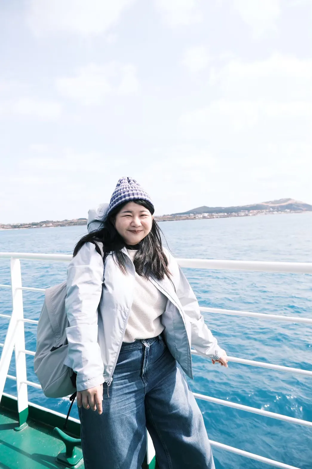 Alice on a ferry with the sea and sky behind her